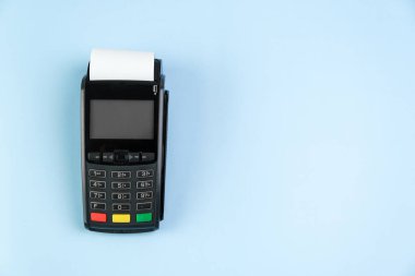 Ödeme terminali POS üzerinde rulo nakit bandı ile mavi arkaplan kopyalama alanı ile