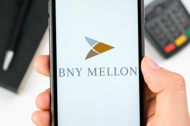 Akıllı telefon ekranındaki BNY Mellon banka logosu ödeme terminalinin arka planında, Mayıs 2021, San Francisco, ABD