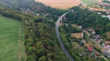 Hareket eden arabalarla köprünün havadan görünüşü ve orman ve tarlanın muhteşem panoramik manzarası.. 
