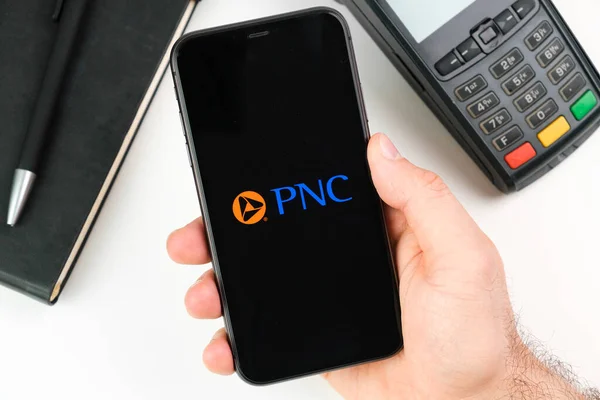 2021年5月，在美国旧金山，在付款终端背景下，人们手上的黑色智能手机屏幕上的PNC银行标志 — 图库照片