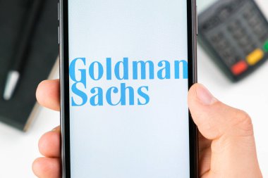 Goldman Sachs 'ın akıllı telefon ekranındaki logosu ödeme terminalinin arka planında, Mayıs 2021, San Francisco, ABD