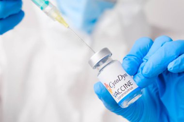 Koronavirüse karşı CytoDyn aşısı koruyucu eldiven ve PPE giysisiyle sağlık görevlisi veya doktor tarafından şırıngaya toplandı, Nisan 2021, San Francisco, ABD