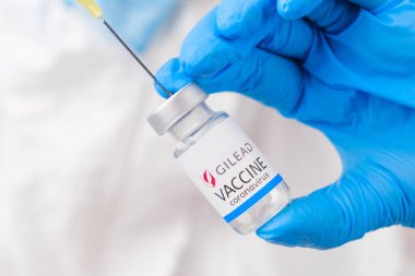 Koronavirüse karşı Gilead aşısı koruyucu eldivenler ve PPE giysisiyle sağlık görevlisi veya doktor tarafından şırıngaya toplandı, Nisan 2021, San Francisco, ABD