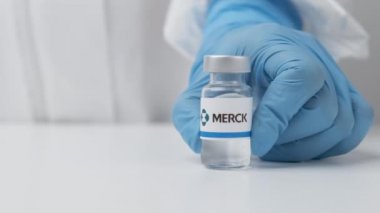 Sağlık görevlileri tarafından masaya konulan plastik eldivenli ve PPE takımlı ilaç şişesi, Mayıs 2021, San Francisco, ABD