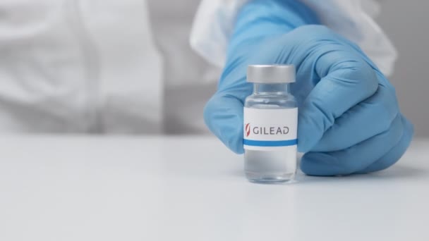 Gilead флакон с лекарствами положить на стол медицинским работником в резиновых перчатках и СИЗ костюм, Май 2021, Сан-Франциско, США — стоковое видео