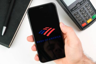 Akıllı telefon ekranındaki Amerikan Bankası logosu ödeme terminalinin arka planında, Mayıs 2021, San Francisco, ABD
