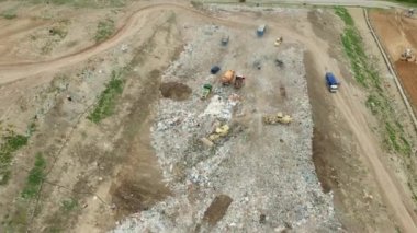 Çöplüğün havadan görünüşü. Çöp kamyonları çöpü dışarı çıkarır. Tüketim ve kirlilik kavramı