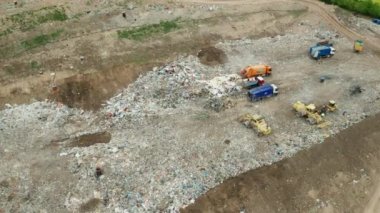 Çöplüğün havadan görünüşü. Çöp kamyonları çöpü dışarı çıkarır. Tüketim ve kirlilik kavramı