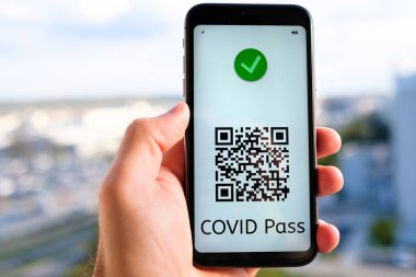 Ekranda QR kodlu ve akıllı telefonlu şifreli bir geçiş. Şehir manzarasının arka planında, Mayıs 2021, San Francisco, ABD.