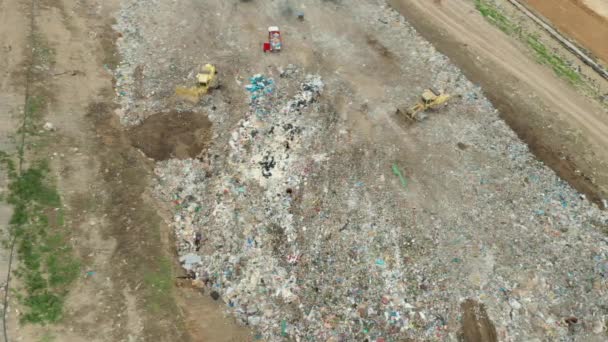 Luftaufnahme einer Mülldeponie oder eines Schrottplatzes. Muldenkipper entladen Abfall auf Mülldeponien. Verwertung oder Recycling von Abfall. — Stockvideo