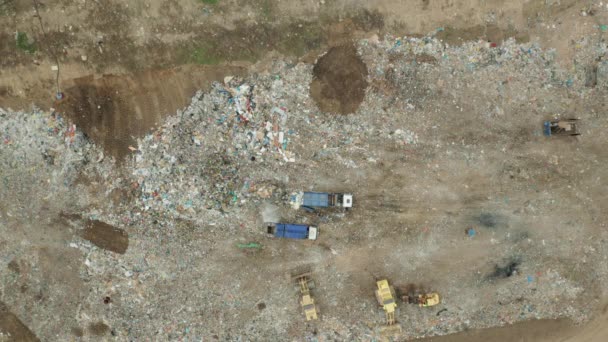 Вид с воздуха на мусорную свалку. Мусоровоз выносит мусор. Концепция потребления и загрязнения — стоковое видео