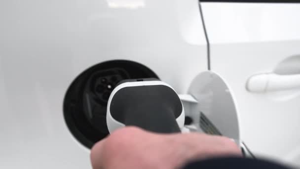 Man hand bevestigen van stroomkabel aan elektrische auto voor het opladen — Stockvideo