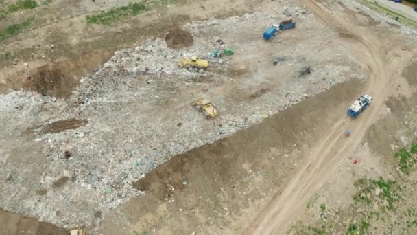 Vue de dessus sur les camions à ordures déchargent les ordures vers une décharge. — Video