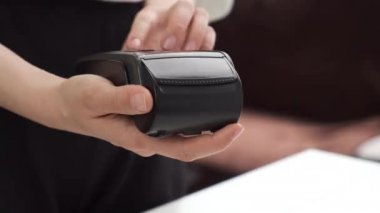 Yaklaşan kadınların elleri düğmelere basar ya da posizyon terminalindeki alışverişlerin toplamına girer. Bir satıcı terminaldeki miktarı girer