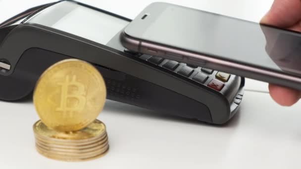 Cerca de mano de hombre sin contacto de pago por teléfono inteligente y monedas de bitcoin sobre la mesa — Vídeo de stock