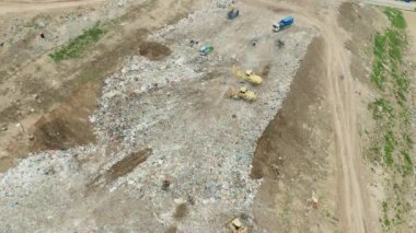 Çöp kamyonlarının üst görüntüsü çöpleri bir çöp sahasına boşaltıyor.