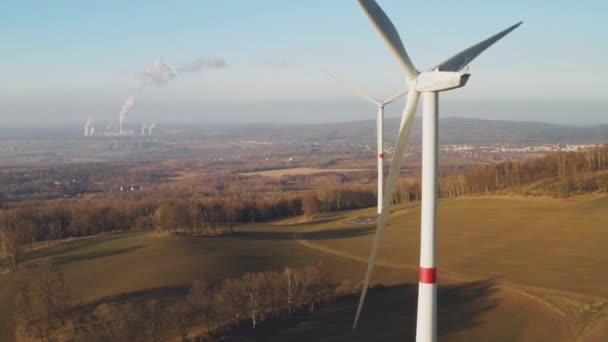 Vindturbinen alstrar elektricitet mot bakgrund av kärnkraftverket. — Stockvideo