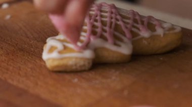 Noel ağacı şeklinde zencefilli kurabiyeleri kraliyet kremalı süslemek. Ev yapımı geleneksel Noel kurabiyeleri 