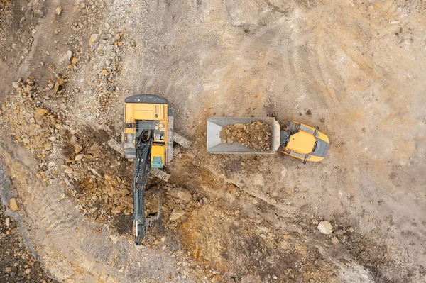 Excavadora industrial pesada cava el suelo y lo transfiere al camión. — Foto de Stock