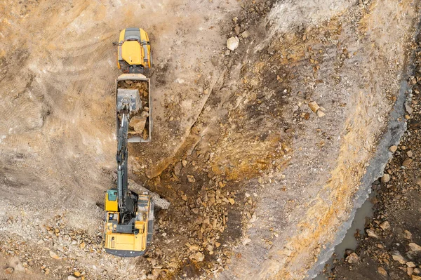 Heavy industrial excavator digs the ground and transfers it to the truck. — Stock Photo, Image