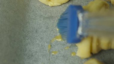 İtalyan kruvasanlarının üzerine silikon fırçayla yumurta sarısı sürüyorum. Puf böreği