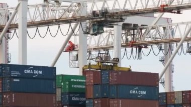 Limandaki endüstriyel vinçle gemiye konteynır yüklüyorum. Limana bir ithalat ve ihracat kargosu. Ağustos 2021. Koper, Slovenya.
