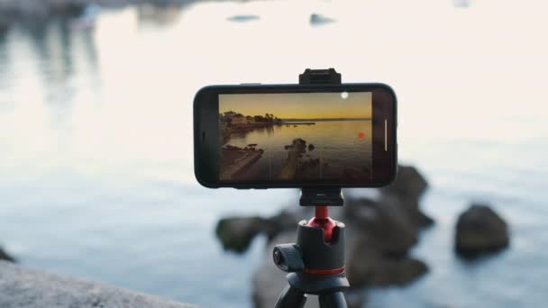 Primer plano de grabación de teléfonos inteligentes lapso de tiempo de salida o puesta del sol en la costa del mar — Vídeos de Stock