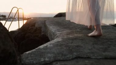 Gün batımında ya da gün doğumunda iskelede yürüyen kadın ayakları.. 