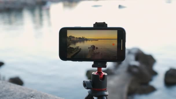 Primer plano de grabación de teléfonos inteligentes lapso de tiempo de salida o puesta del sol en la costa del mar — Vídeos de Stock
