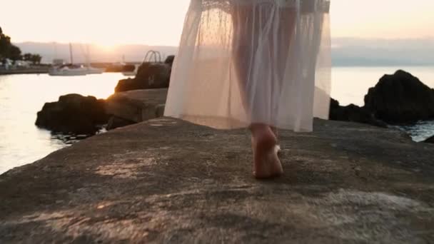 Primeros pies femeninos caminando a lo largo del muelle al atardecer o al amanecer. — Vídeos de Stock