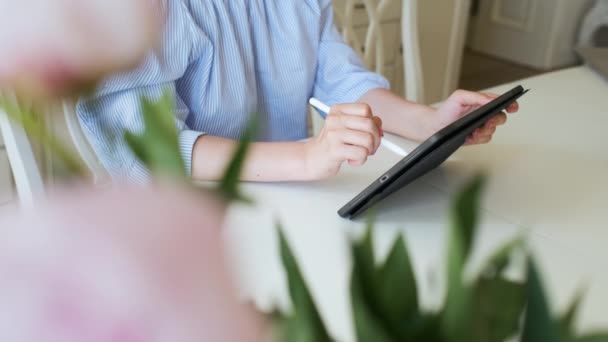 Mulher trabalhando no tablet usando lápis no interior moderno claro. Artista freelancer ou designer de interiores sentado na sala de estar e desenho. — Vídeo de Stock