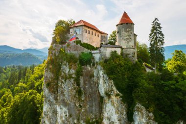 Slovenya 'daki dağın yamacındaki Ortaçağ Kanlı Kalesi' nin havadan görünüşü