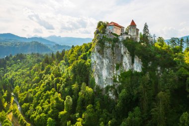 Slovenya 'daki dağın yamacındaki Ortaçağ Kanlı Kalesi' nin havadan görünüşü