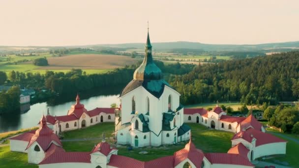 En marche arrière au-dessus de l'église de pèlerinage de Saint Jean de Nepomuk sur la Colline Verte au coucher du soleil. — Video