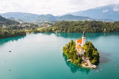 Güzel dağ gölü. Julian Alpleri 'nin arka planındaki adada küçük bir hac kilisesi olan turkuaz mavi suyla kanadı..