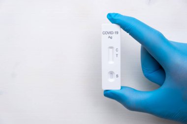 Doktorlarda hastalığın hızlı tespiti için Covid-19 antijenik testi plastik eldivenleri fotokopi alanı ile birlikte teslim etti. Hızlı streptokok kitinden Coronavirus test kaseti. 