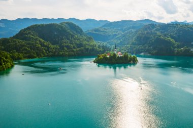 Julian Alpleri 'nin arka planında küçük adalı turkuaz mavi su ile Bled Gölü.