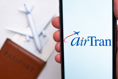 Havayolları şirketi uygulaması veya logosu arka planda pasaport, uçuş kartı ve uçak olan bir cep telefonunda sergilendi, Eylül 2021, San Francisco, ABD