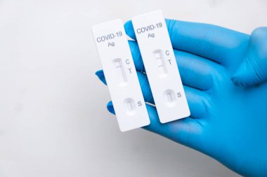 Doktorlarda hastalığın hızlı tespiti için pozitif ve negatif Covid-19 antijenik testi plastik eldivenleri fotokopi alanı ile birlikte teslim etti. Hızlı streptokok kitinden Coronavirus test kaseti. 