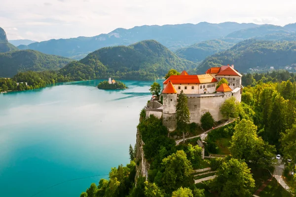 슬로베니아에 있는 청록색 물로 둘러싸인 블 레드 호수 밑 산의 절벽에 있는 중세 시대의 블 레드 성을 공중에서 내려다본 모습 — 스톡 사진