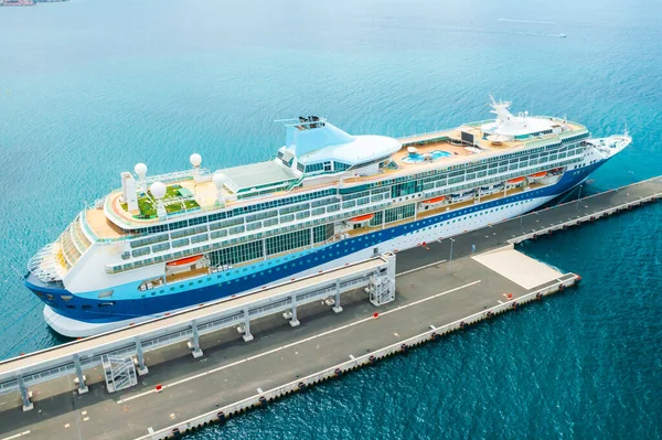 Vista aérea de um navio de cruzeiro de luxo ou linear com uma piscina e campo de golfe no telhado atracado na marina. — Fotografia de Stock