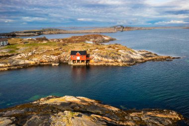 Geniş fiyort suları ve dik dağ yamaçlarıyla sarılmış kayalık bir adada küçük bir ev Norveç 'in sakin ama güçlü doğal güzelliğini yakalıyor..