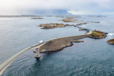 Kamyon, Atlantik Okyanusu Yolu 'nun kıvrımlı bir kesiminde Norveç' te deniz ve engebeli manzarayla çevrili küçük kıyı adalarını birbirine bağlıyor.