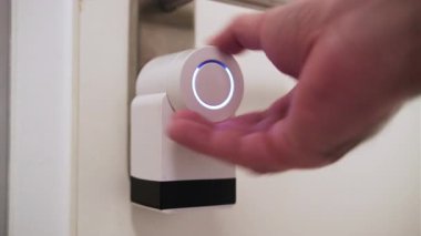 Modern ev güvenliği konsepti olan akıllı kapı kilidini kapatan bir adamın eli..