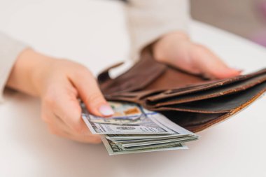 Kadın, kişisel mali işleri yönetiyor, cüzdandaki nakit parayı düzenliyor. Enflasyon ve ekonomik istikrar kavramı.