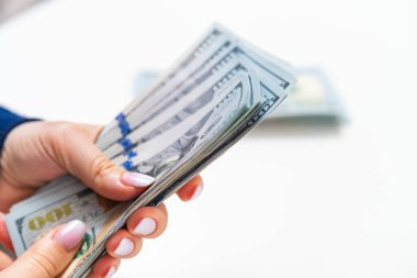 Beyaz arka planda izole edilmiş Amerikan doları gösteren bir kadın. Tasarruf ve bütçe teması.