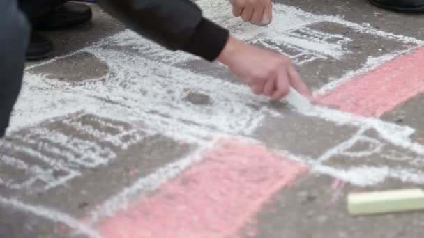 Los niños dibujan sobre el asfalto — Vídeo de stock