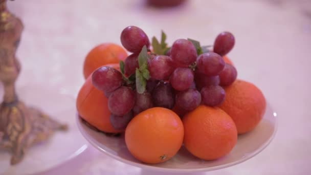 Uvas y naranjas sobre una mesa en el restaurante — Vídeo de stock