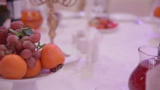 Uvas y naranjas sobre una mesa en el restaurante — Vídeo de stock