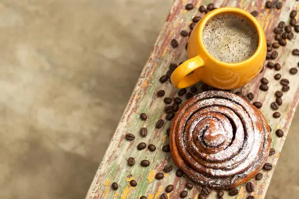 Bir fincan mis kokulu kahve ve tatlı bir kanelbulle. Kopyalama alanı.